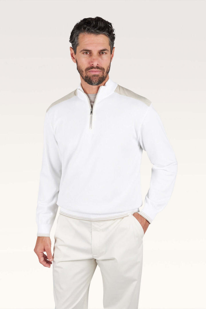Homme portant un chandail à demi-zip blanc avec col montant, coupe droite et tissu doux, style décontracté chic moderne.