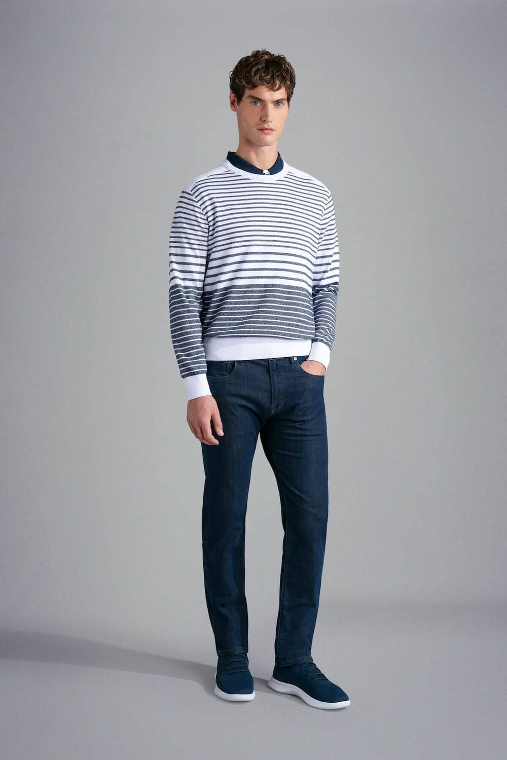 Homme portant un chandail rayé en coton Paul & Shark Riviera, jeans foncés et baskets, style élégant.