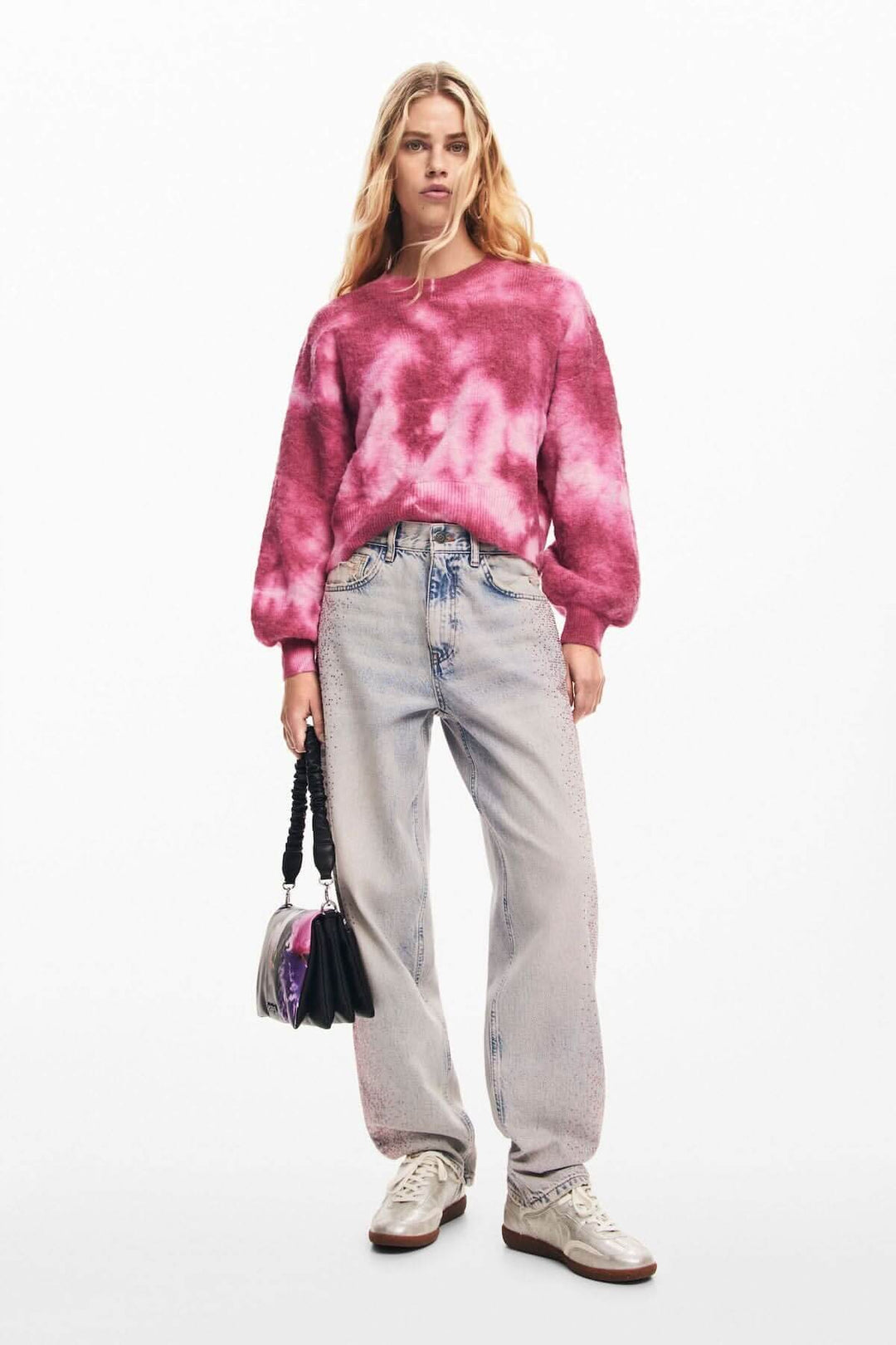 Chandail délavé à manches longues et col rond, porté avec un jean et un petit sac à main, style décontracté.