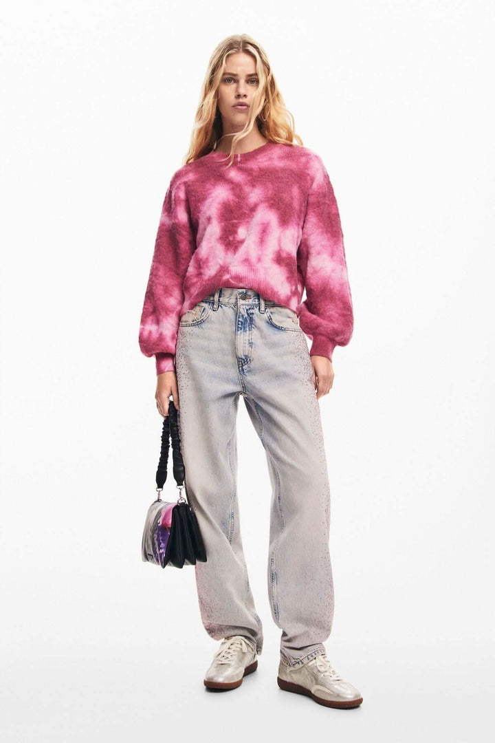 Chandail délavé à manches longues et col rond, porté avec un jean et un petit sac à main, style décontracté.
