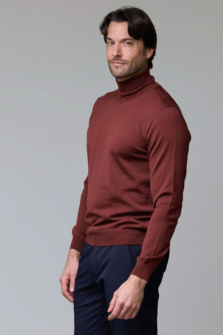 Homme portant un chandail en laine mérinos fine, col rond tricoté, couleur brique, adapté pour un style intemporel et élégant.