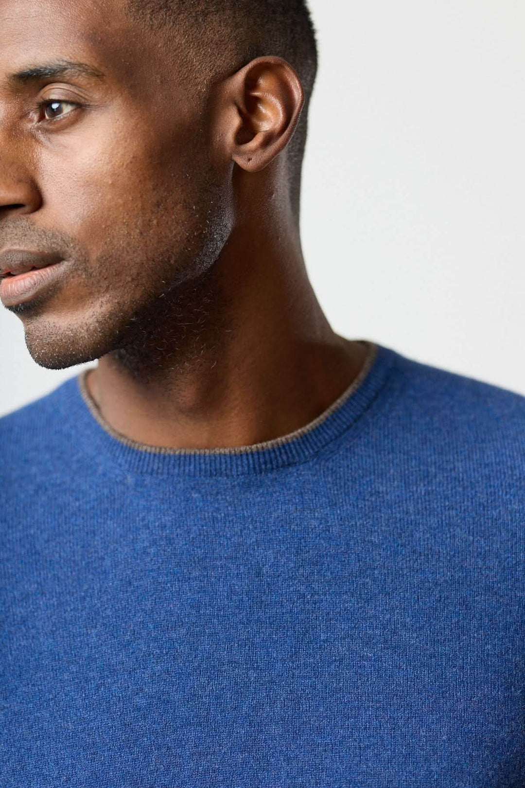 Homme portant un chandail en laine vierge et cachemire Gran Sasso bleu, élégant et confortable, avec détails sophistiqués.