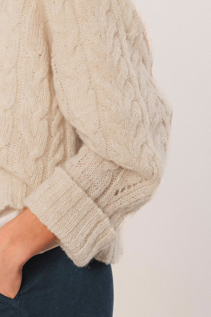 Chandail en maille torsadée beige avec manches amples et finitions côtelées, parfait pour un look décontracté chic.