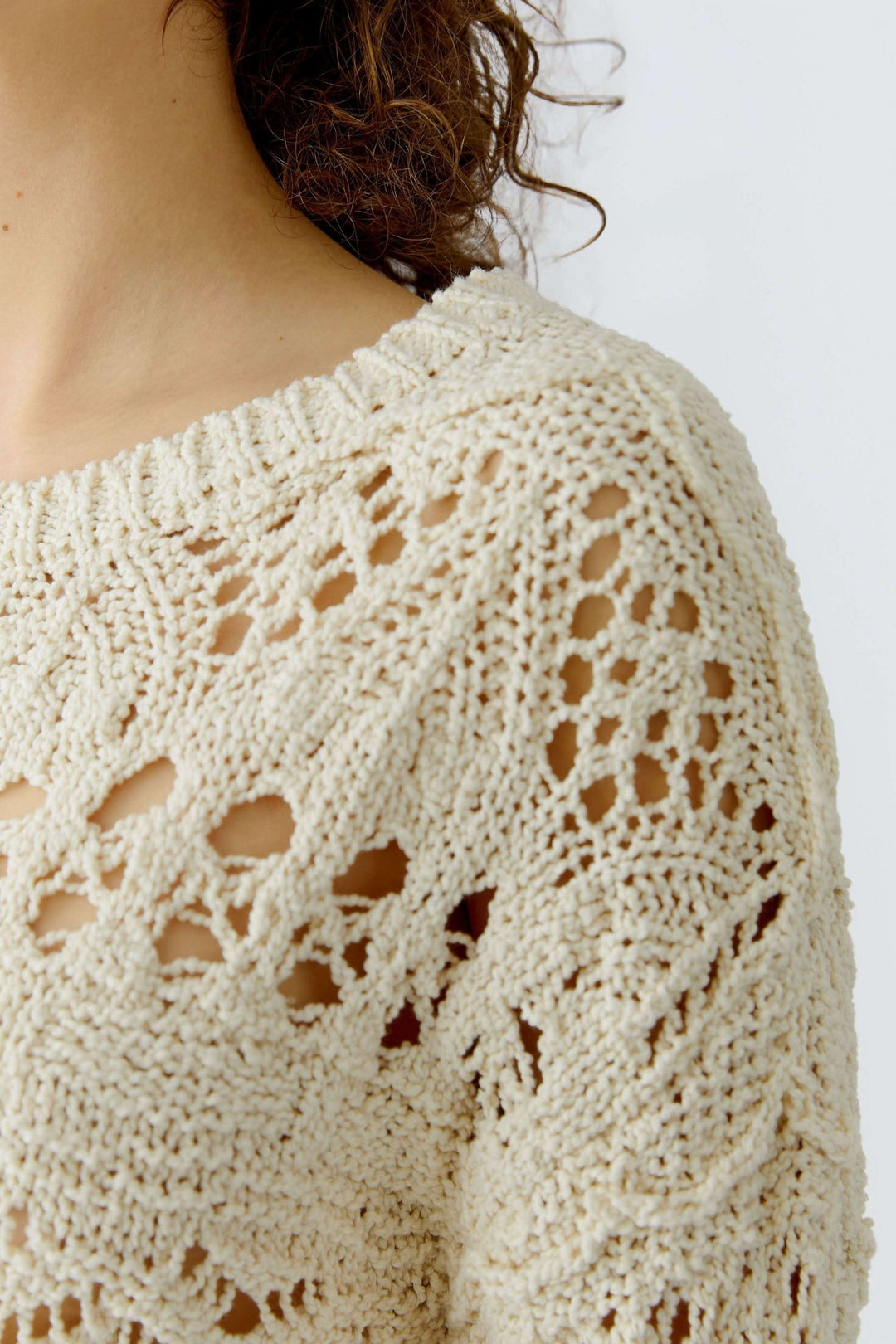 Chandail en maille ajourée avec motif travaillé et texture délicate, coupe décontractée et encolure ronde, féminin et intemporel.