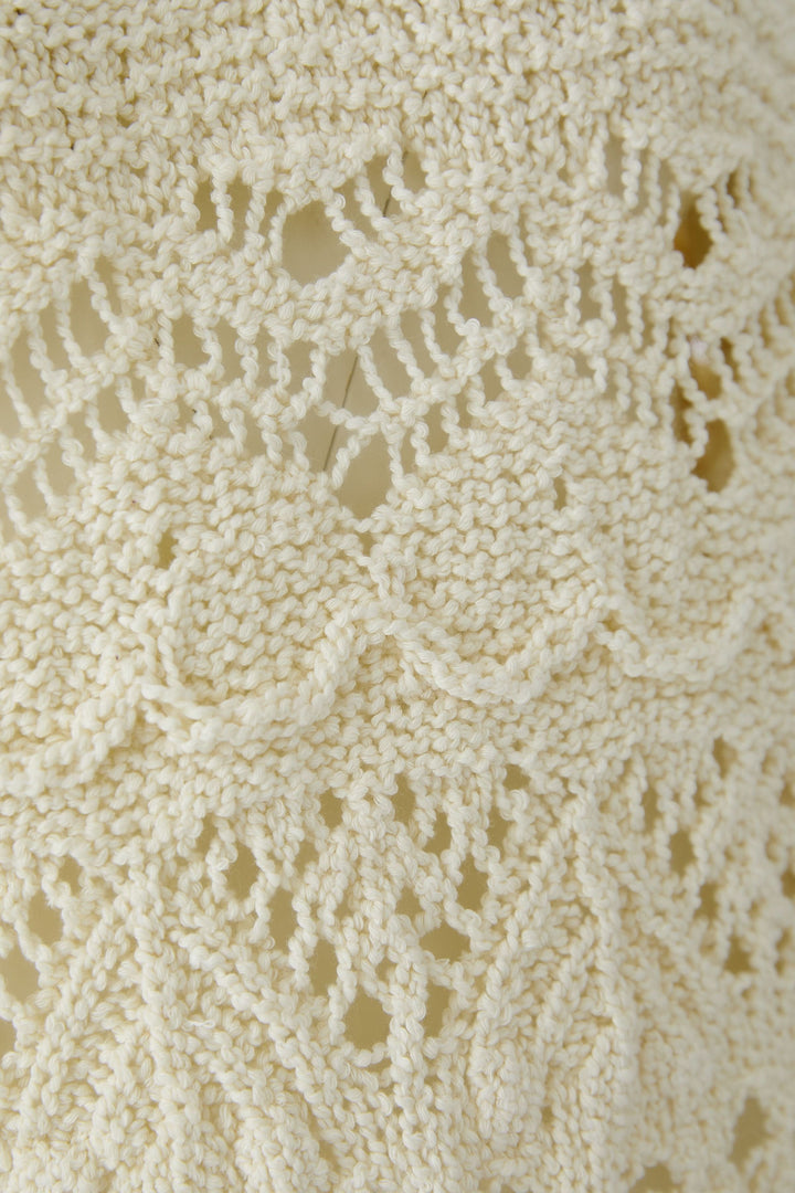 Chandail en maille ajourée avec motif texturé et détails féminins, idéal pour un style décontracté et confortable.