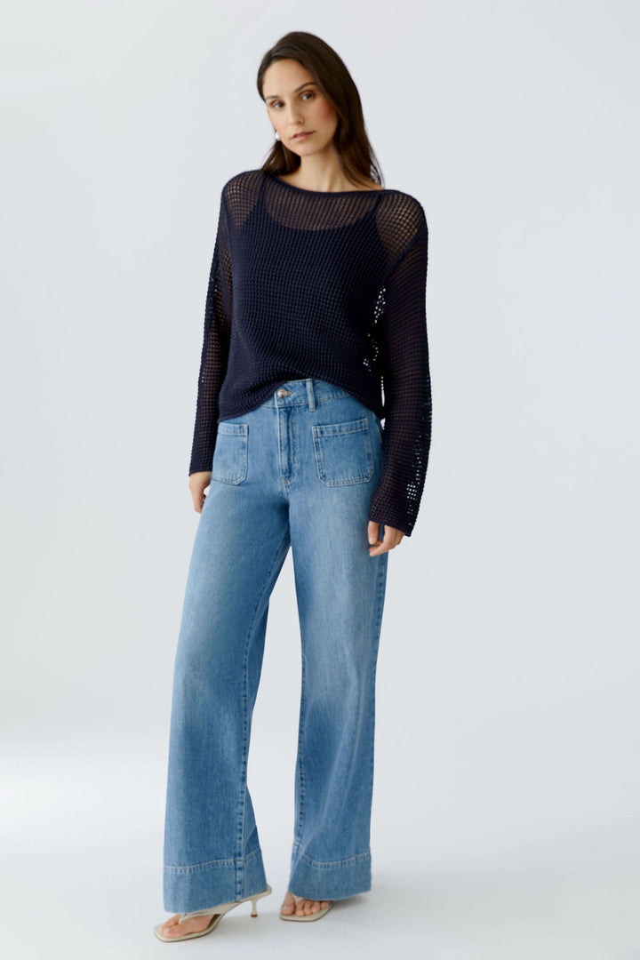Chandail en maille ajourée à manches longues de style moderne avec jeans.