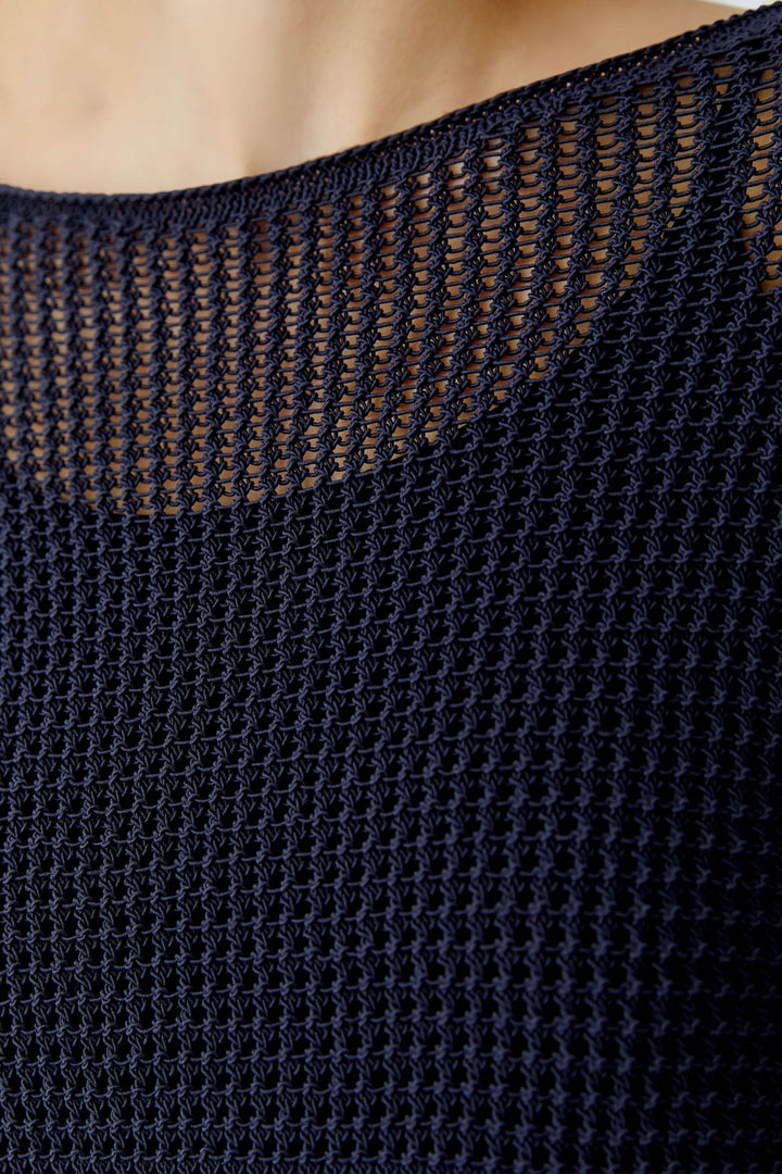 Chandail en maille ajourée à manches longues, texture filet subtile et moderne, idéal pour superposition avec silhouette contemporaine.