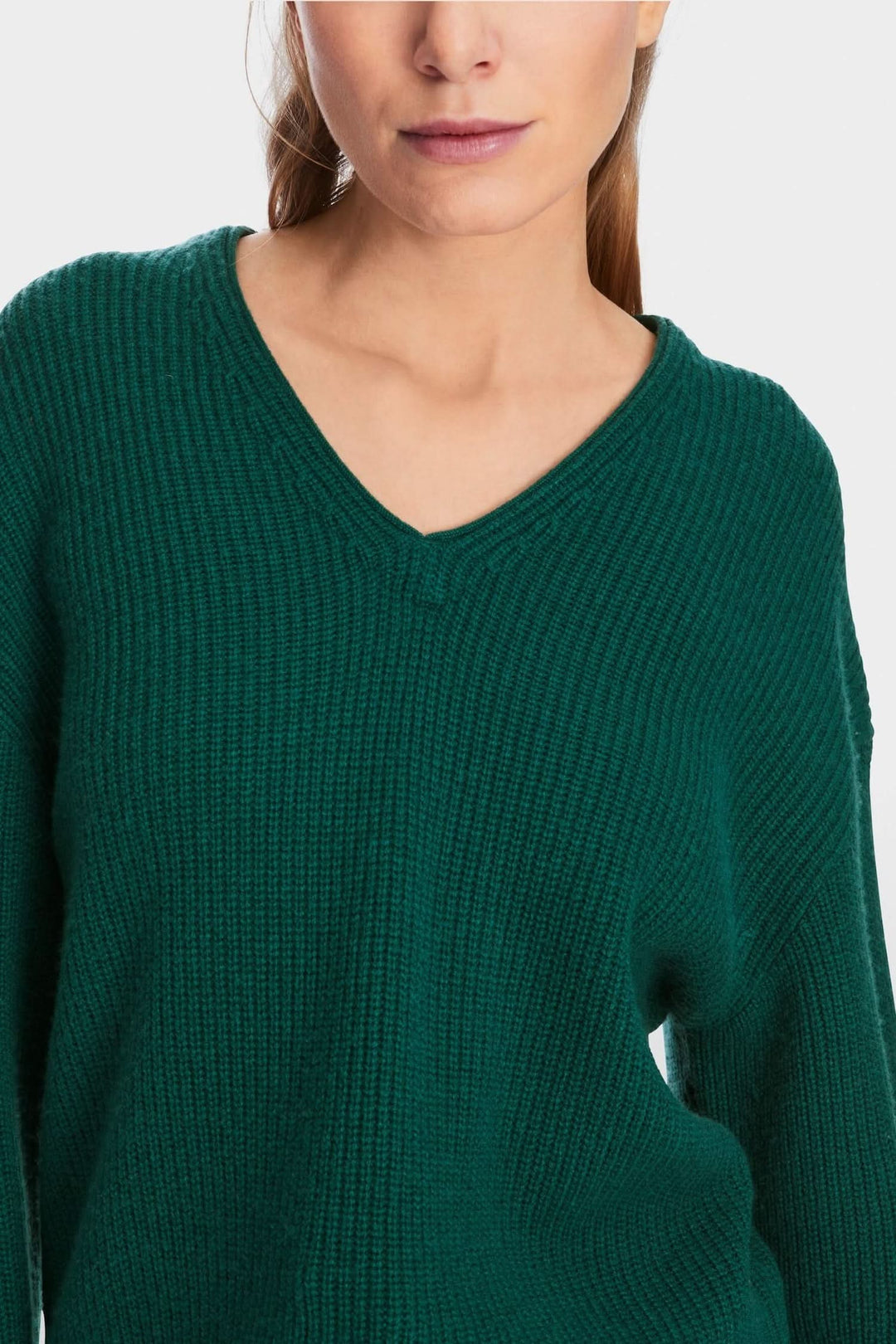 Chandail en mailles vert avec col en V, coupe large, idéal pour le confort et la chaleur.