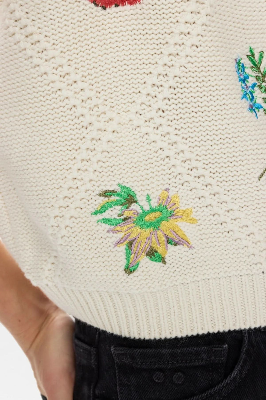 Chandail en tricot brodé à manches courtes avec broderies florales délicates et coupe ample pour une allure naturelle et élégante.