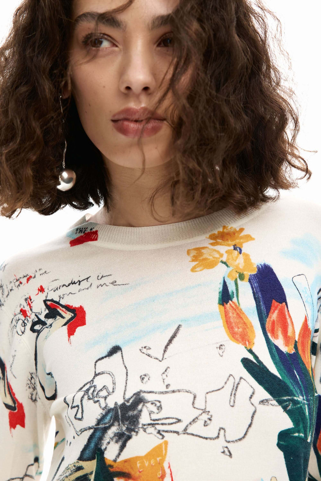 Femme portant un chandail fin avec plantes, motif artistique, manches longues, coupe ajustée, encolure ronde, mode quotidienne et soignée.