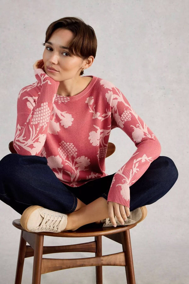 Femme portant un chandail imprimé à manches longues Olive, assise sur une chaise.