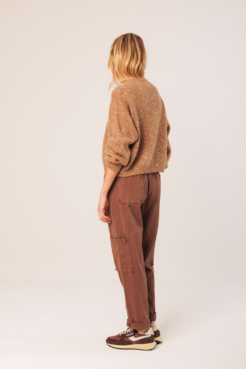 Chandail maille texturée beige avec col rond et manches bouffantes, porté avec un pantalon marron.