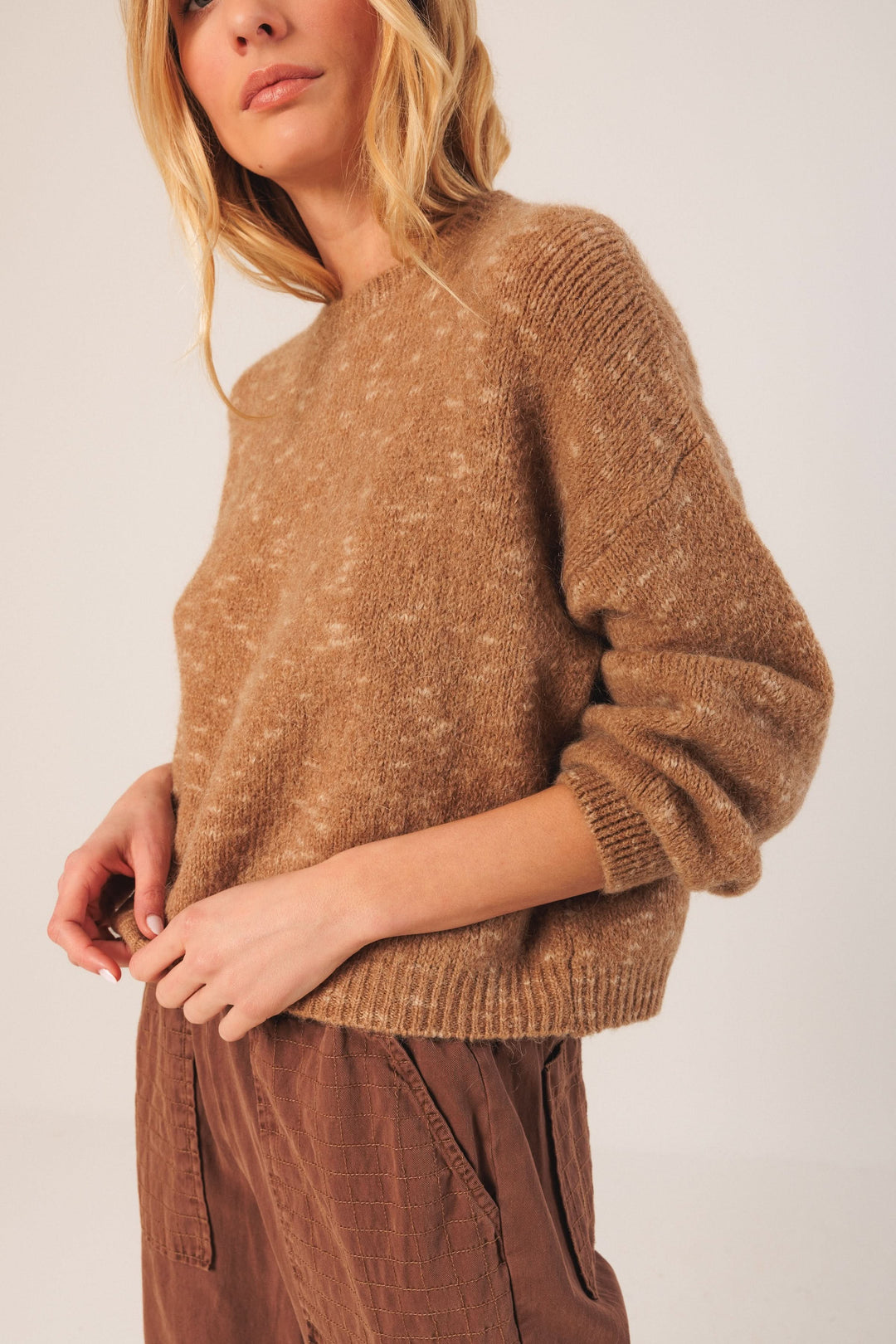 Chandail maille texturée beige à col rond et manches bouffantes, parfait pour un look décontracté en saison froide.
