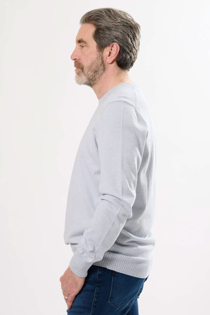 Homme en chandail manches longues gris en coton et cachemire, vue de profil, élégant et confortable.