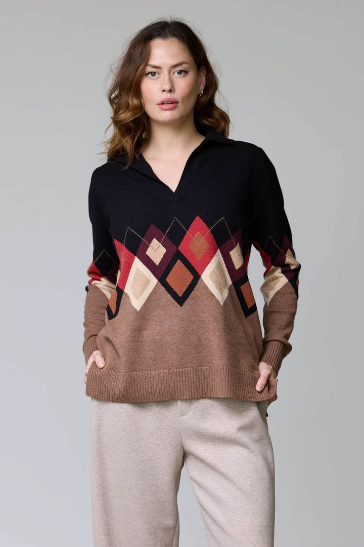 Femme portant un chandail à motif losanges multicolores avec col ouvert, texture douce et coupe droite, idéal pour la saison fraîche.
