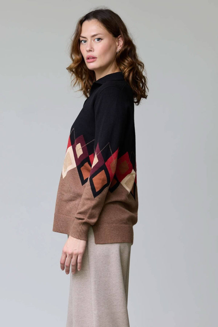 Femme portant un chandail à motif losanges avec col ouvert et manches multicolores, élégant et confortable pour la saison fraîche.