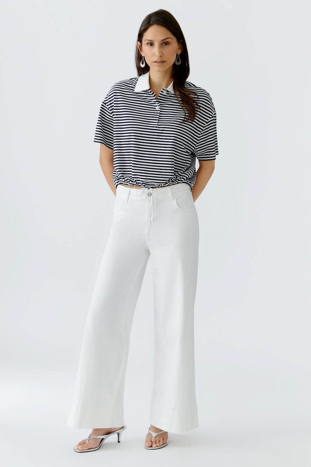 Chandail polo à rayures avec cordon porté par mannequin, coupe fluide et manches courtes, parfait pour un look casual chic.