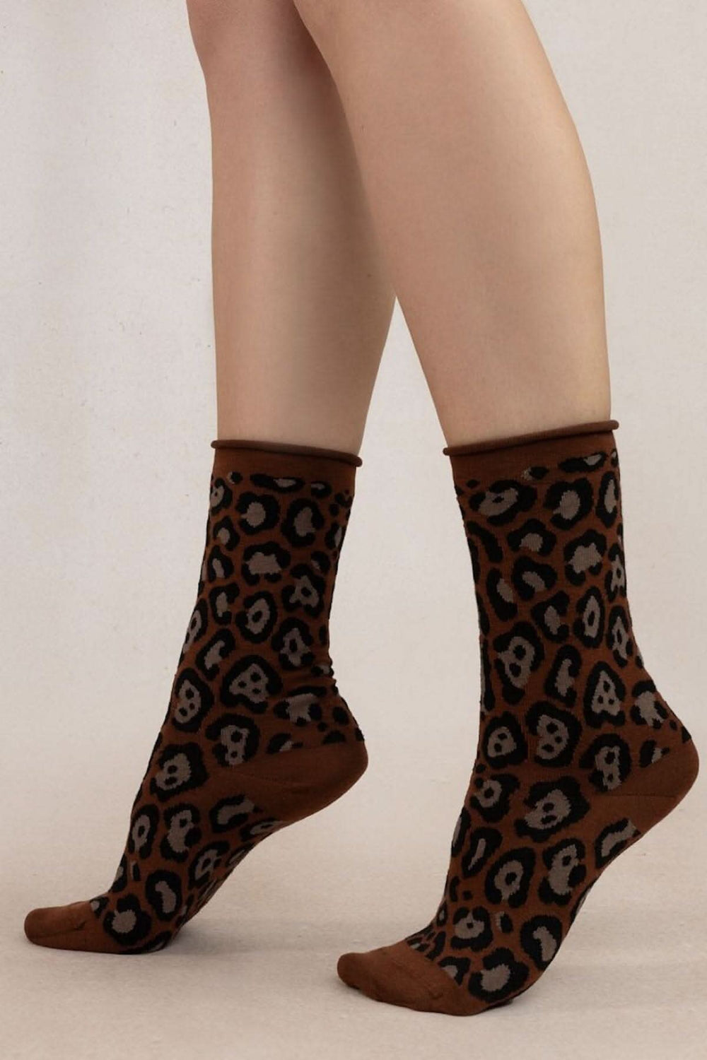 Chaussettes léopard confortables en laine et coton, avec un imprimé intégral tendance sur un fond marron.