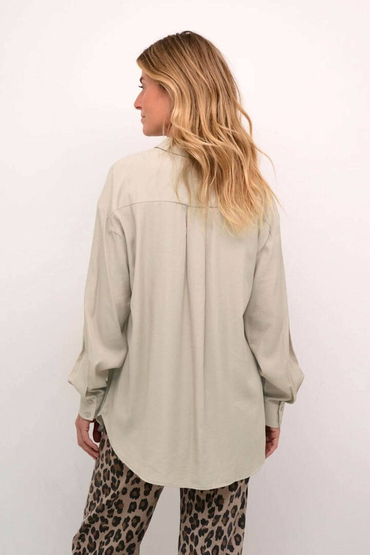 Chemise moderne à manches amples, vue de dos, avec poches sur la poitrine et coupe fluide.