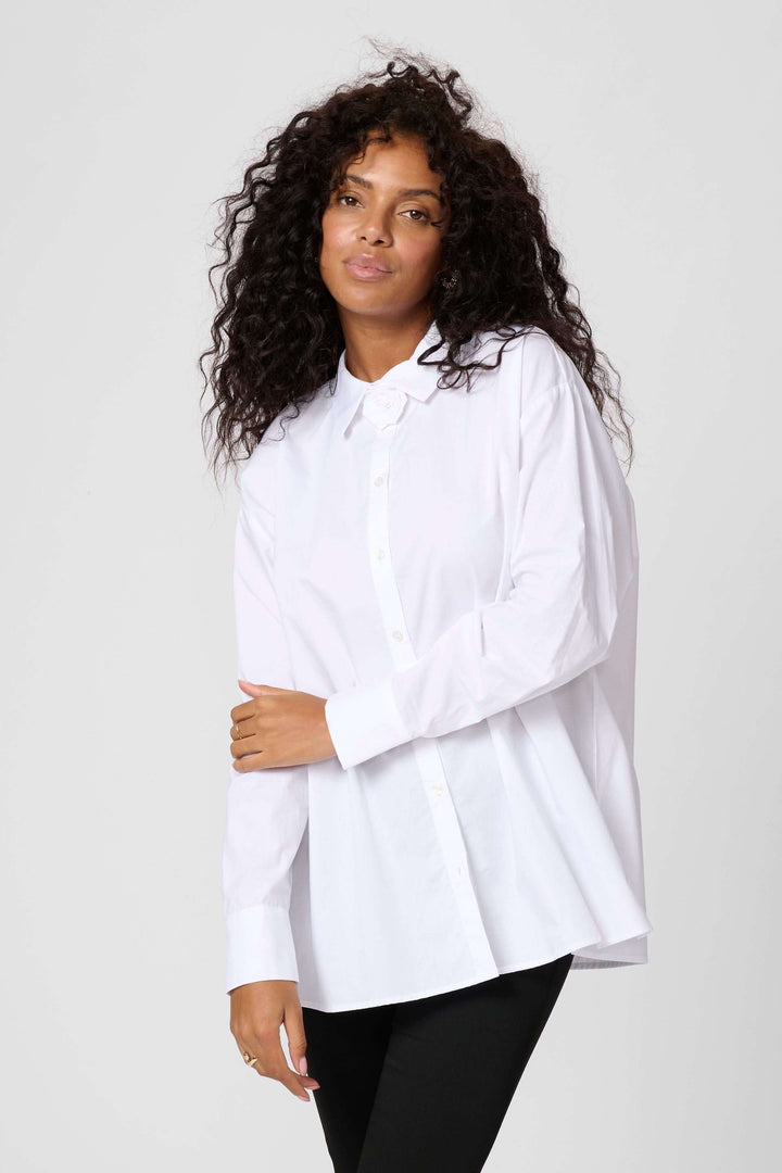 Chemise Mira blanche avec col fleuri, coupe ample, idéale pour un look chic et décontracté.