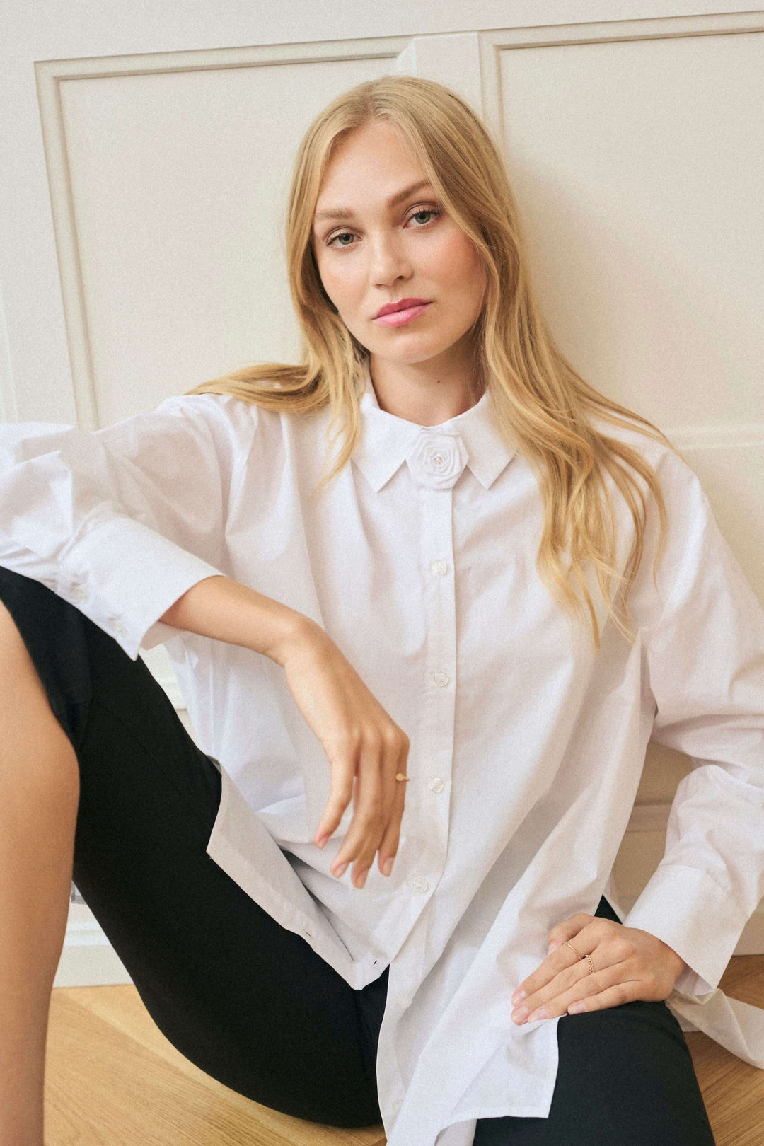 Chemise Mira en popeline de coton avec col brodé fleuri, portée par une femme, style ample et chic.
