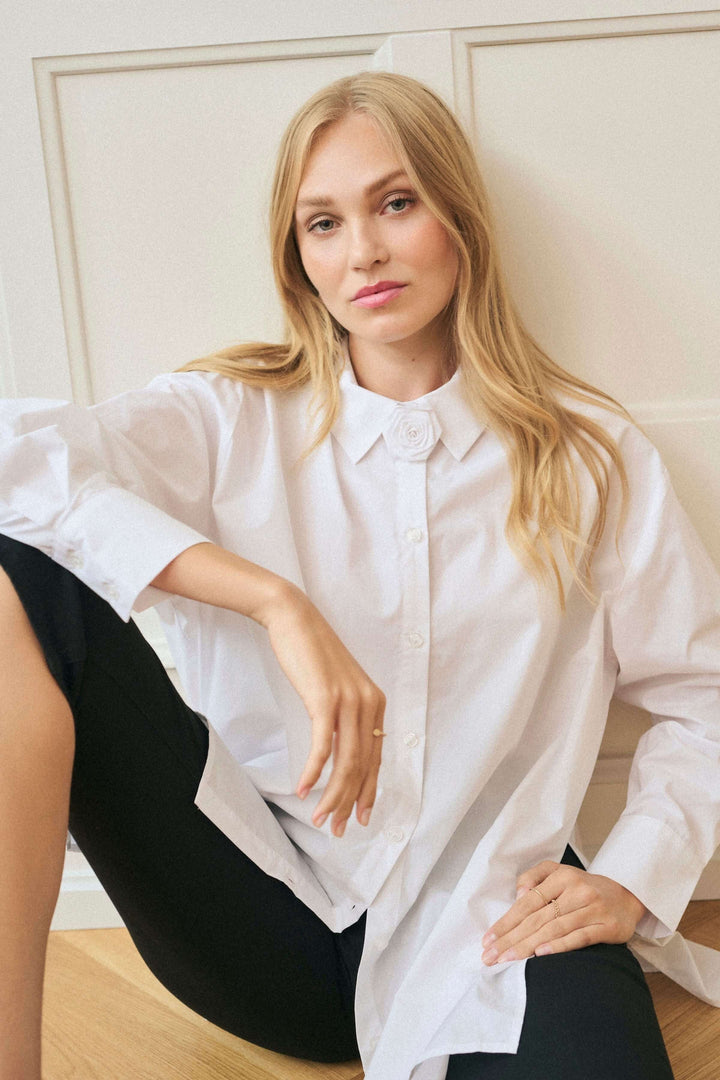 Chemise Mira en popeline de coton avec col brodé fleuri, portée par une femme, style ample et chic.