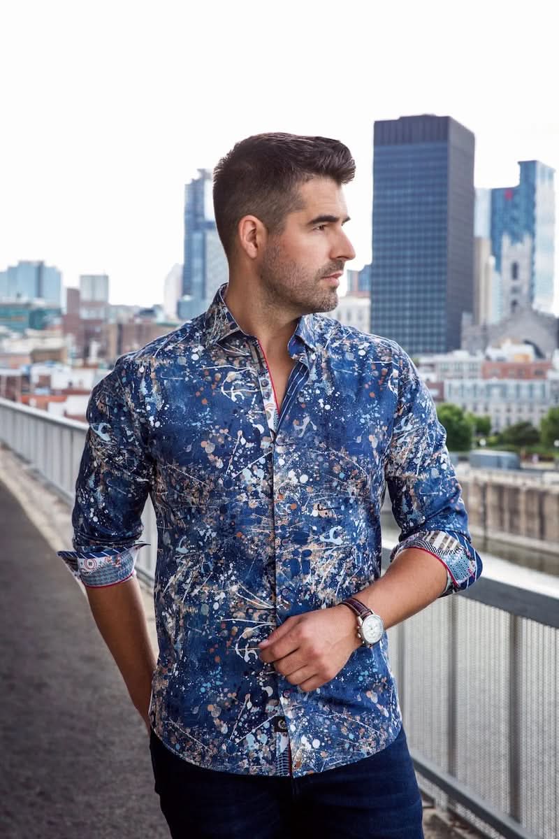 Homme portant une chemise Stapelton en coton bleu avec motifs sophistiqués, se tenant sur un pont en milieu urbain.