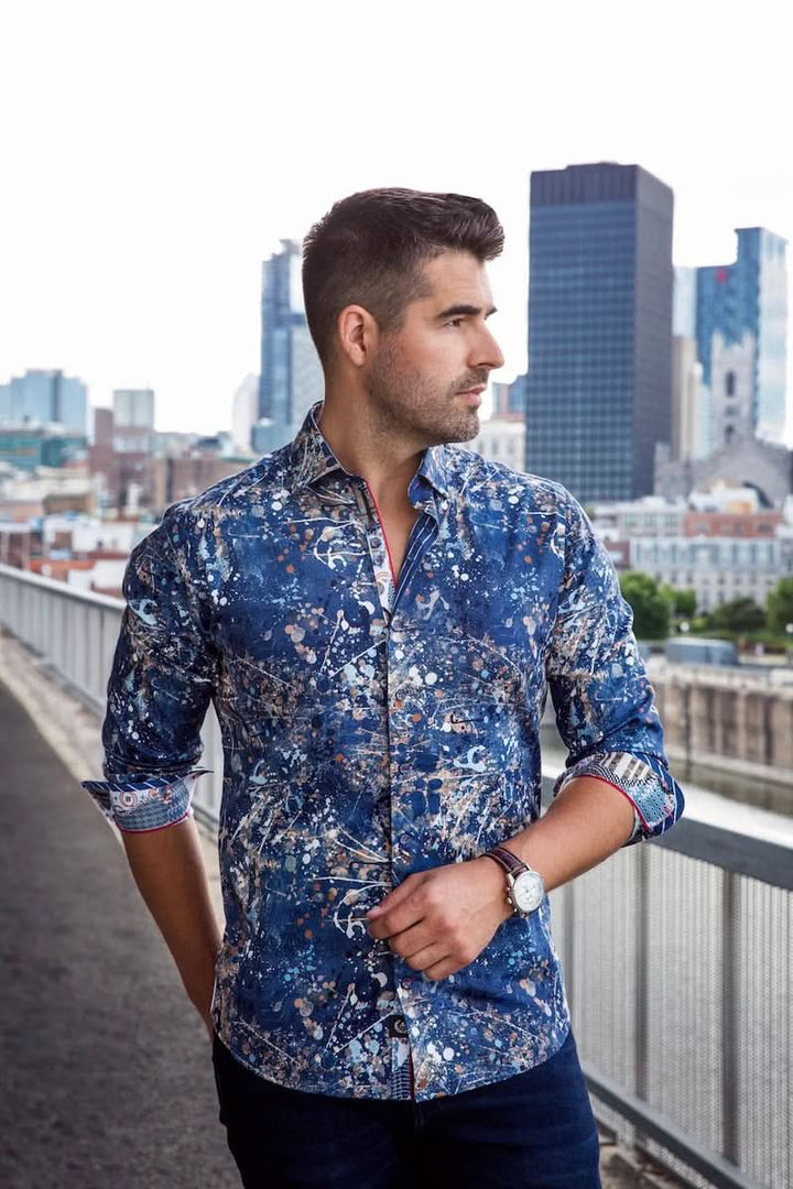 Homme portant une chemise Stapelton en coton bleu avec motifs sophistiqués, se tenant sur un pont en milieu urbain.
