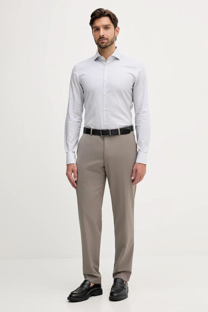 Homme portant une chemise ajustée à micro-motif, élégante et moderne, idéale pour bureau et occasions habillées.