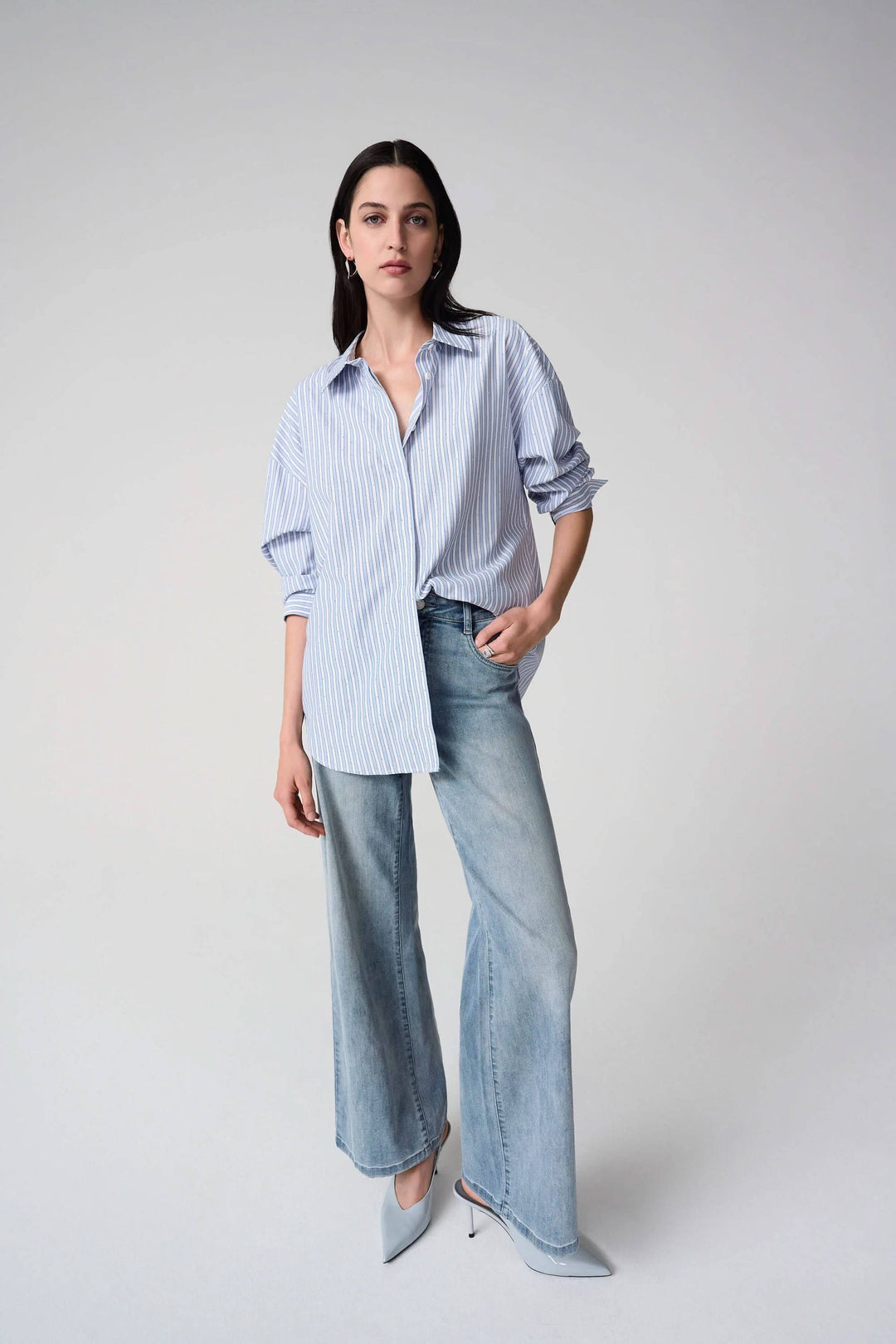 Femme portant une chemise avec paillettes et rayures verticales, tenue contemporaine et polyvalente parfaite pour toutes occasions.