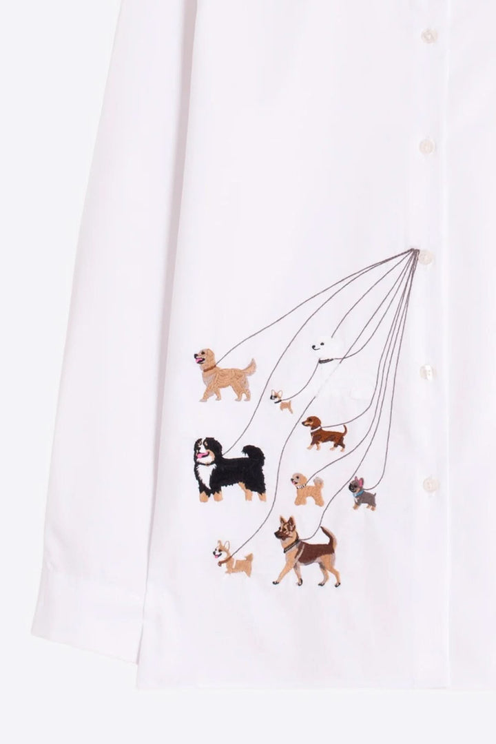 Chemise brodée de chiens avec broderie ludique et élégante, présentant divers chiens sur tissu blanc avec manches longues.