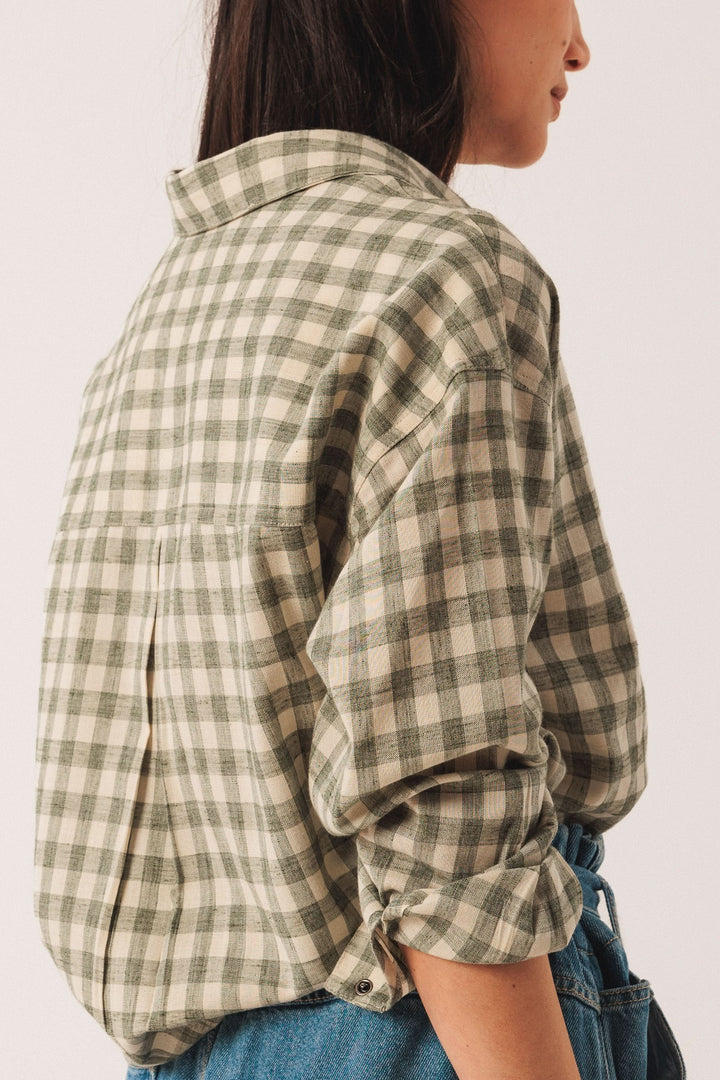 Chemise à carreaux à la coupe décontractée, manches retroussées, vue de profil.