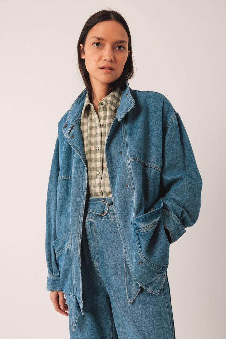 Femme en veston en denim bleu sur chemise à carreaux, style décontracté et moderne, look polyvalent.