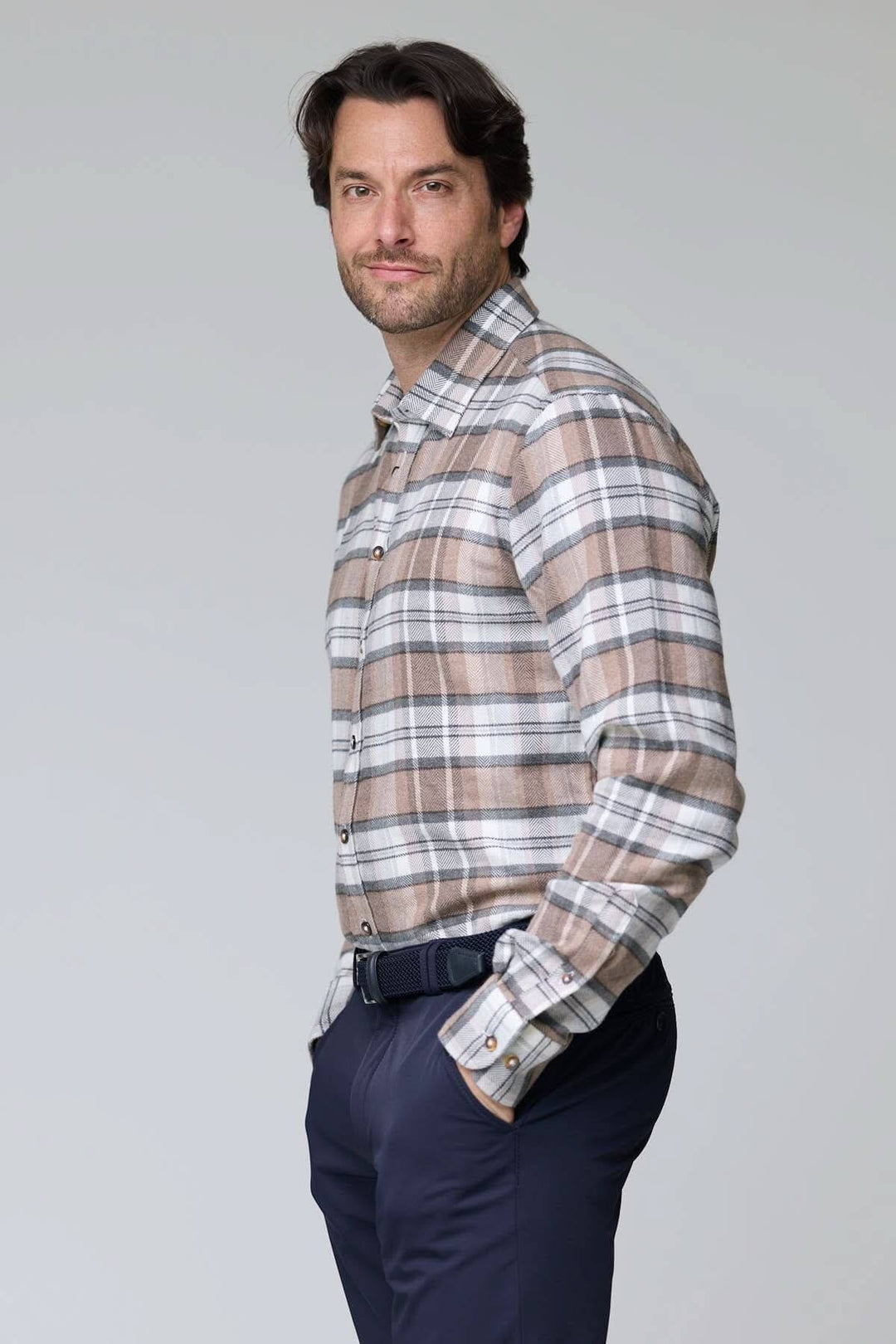 Homme portant une chemise à carreaux chevrons beige et gris en flanelle brossée, coupe ajustée, parfait pour un look élégant et décontracté.