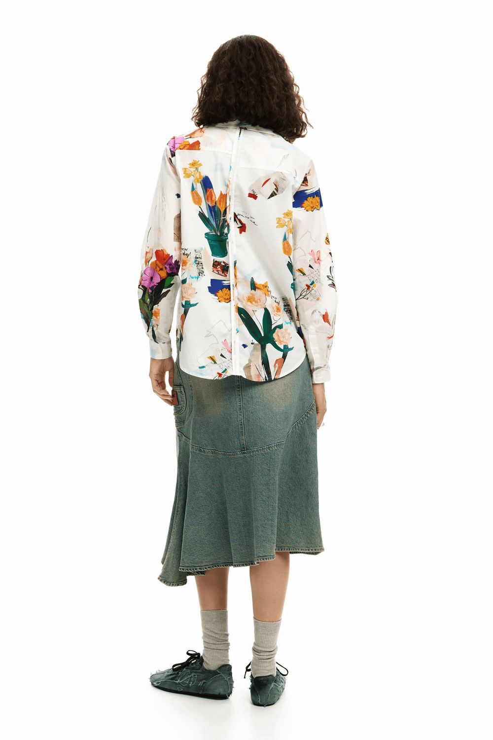Femme portant une chemise collage fleurs avec un imprimé artistique, vue de dos, créant une silhouette fluide et moderne. Style décontracté.