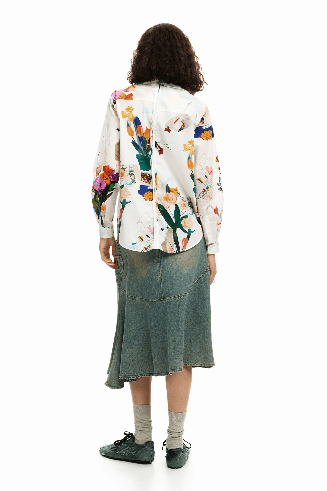 Femme portant une chemise collage fleurs avec un imprimé artistique, vue de dos, créant une silhouette fluide et moderne. Style décontracté.