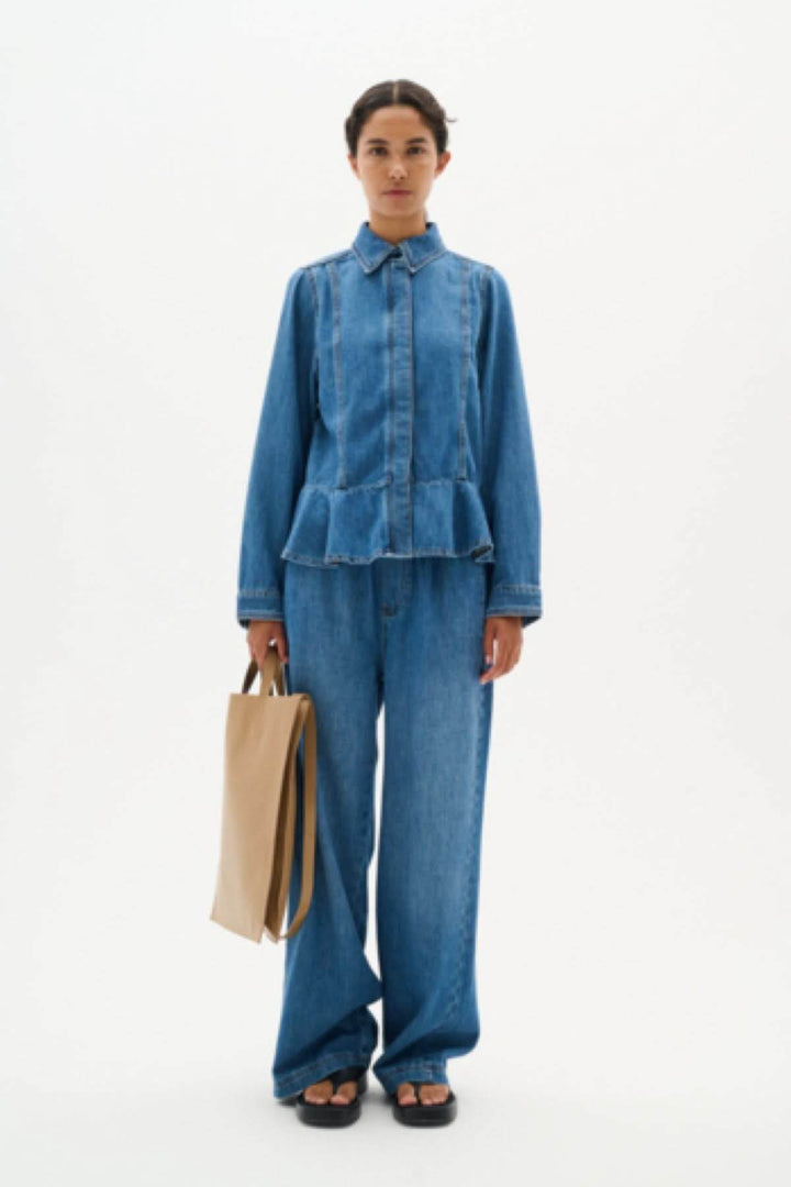 Chemise en jeans péplum Sophina avec col structuré et ourlet flatteur, associée à un pantalon en denim.