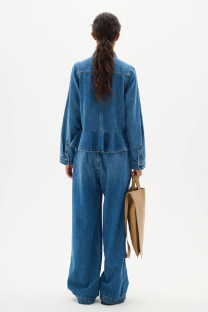 Vue arrière de la chemise en jeans Sophina, style péplum, portée avec un pantalon large et un sac.