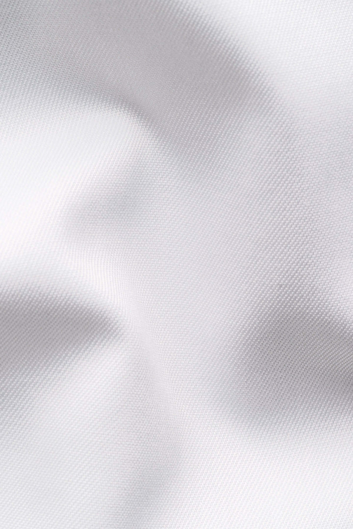 Tissu blanc élégant et texturé, idéal pour une chemise habillée raffinée et confortable.