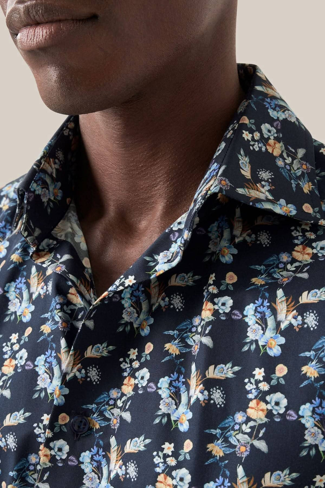 Chemise imprimé fleurs à manches longues avec col, design floral élégant sur fond sombre.