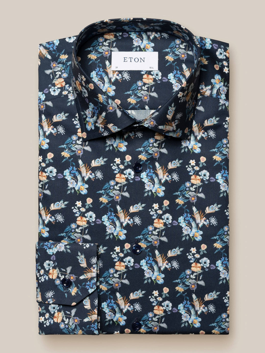 Chemise Eton imprimée de fleurs sur fond bleu marine, avec col et boutons devant.