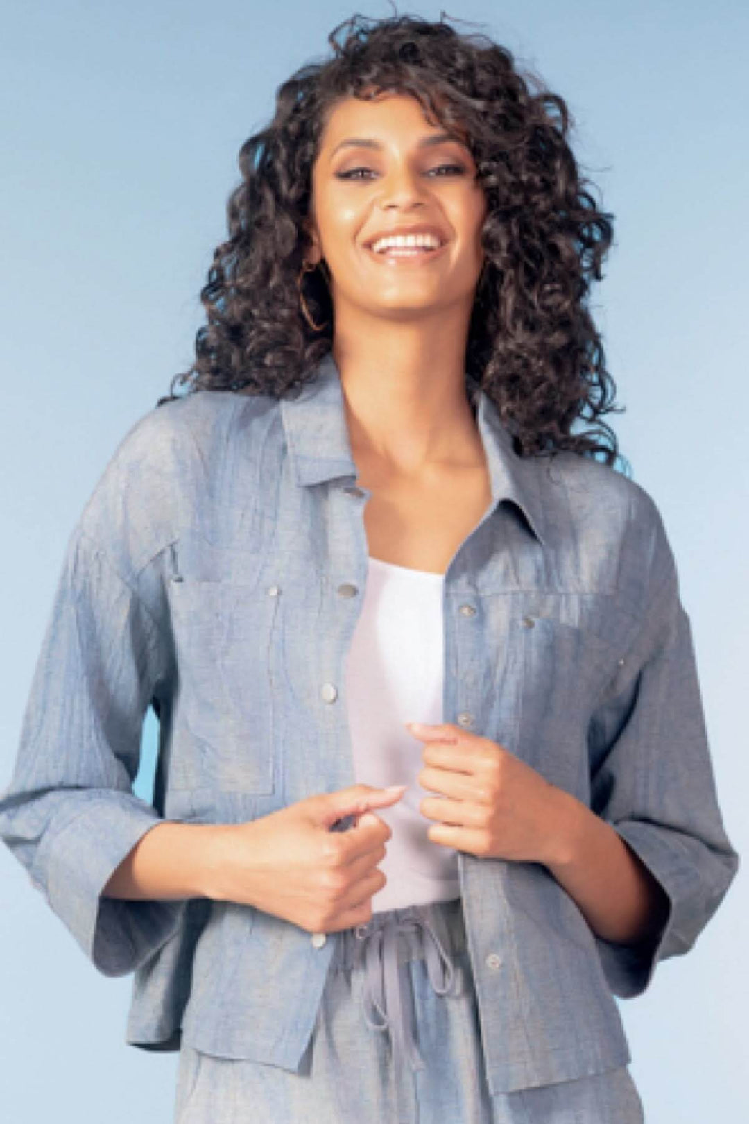 Femme portant une chemise légère à poches plaquées avec manches trois-quarts, parfaite pour un look structuré ou décontracté.