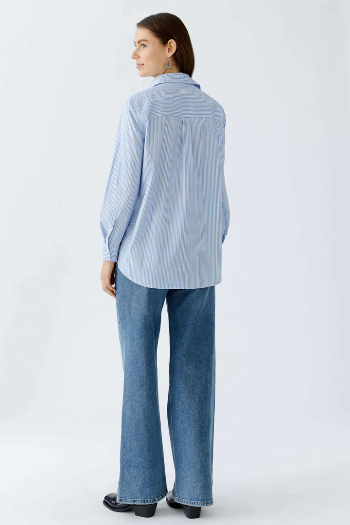 Chemise longue à rayures sportives avec galets contrastants, vue arrière, coupe décontractée en A, ourlet arrondi, femme portant un jean.