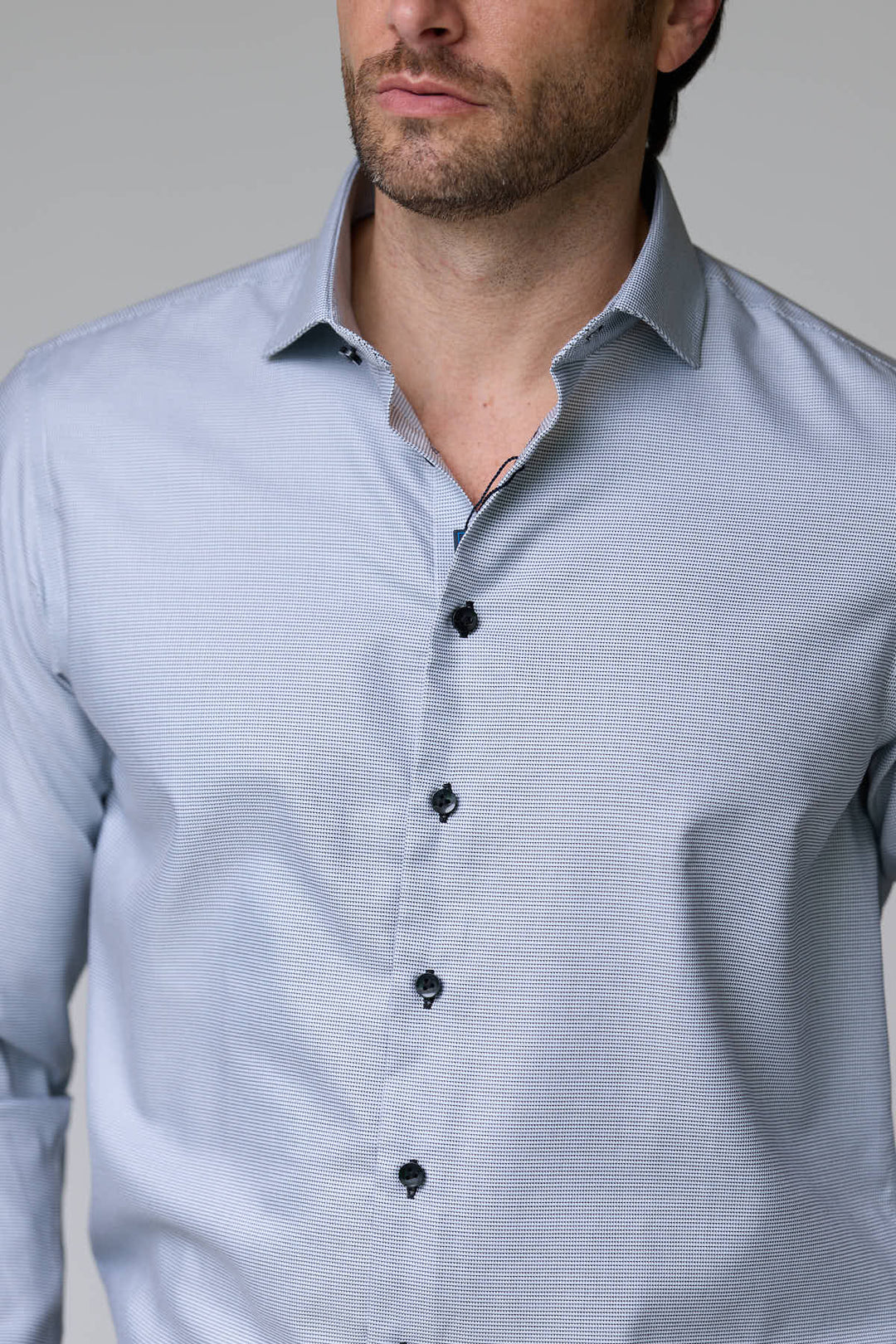 Homme portant une chemise à micro-motif texturé avec coupe ajustée et col semi-rigide, élégante et confortable.