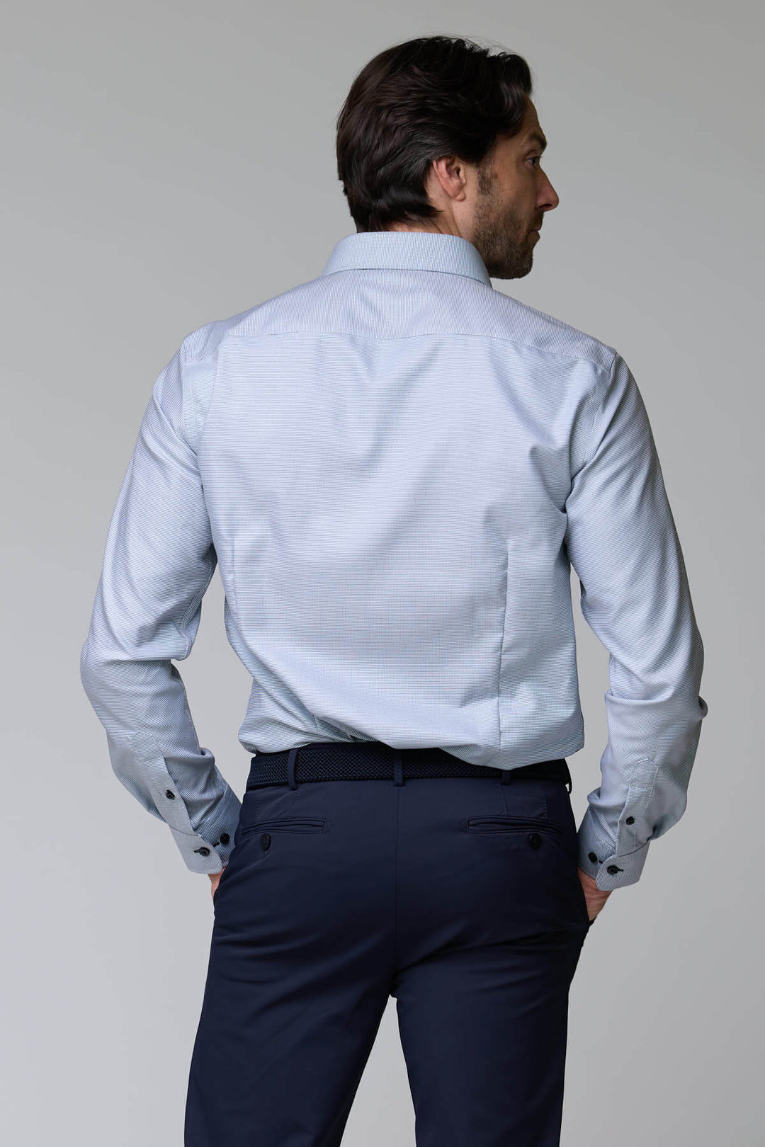 Homme portant une chemise à micro-motif texturé, ajustée et élégante, idéale pour le bureau ou occasions chic.