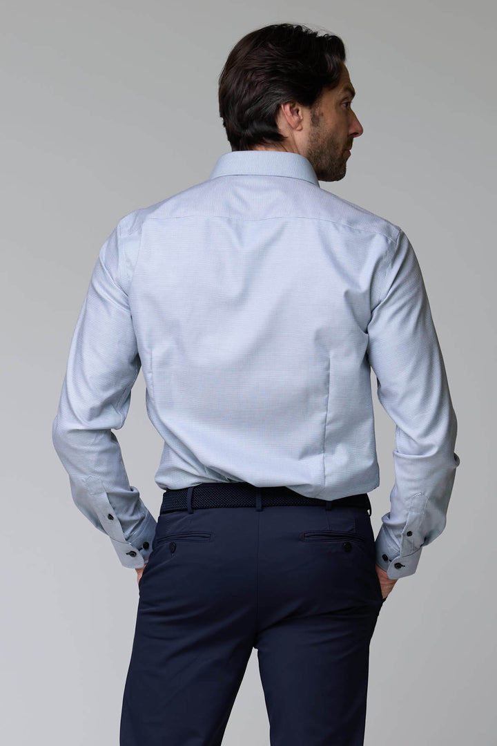 Homme portant une chemise à micro-motif texturé, ajustée et élégante, idéale pour le bureau ou occasions chic.
