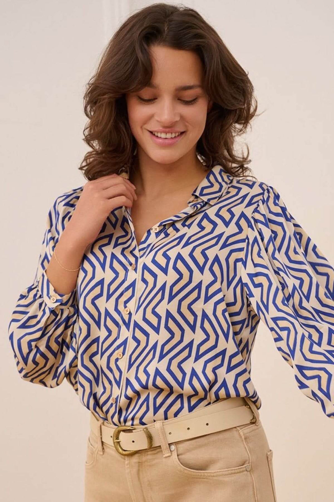 Chemise à motifs géométriques bleu et beige, col classique et manches longues, style décontracté.