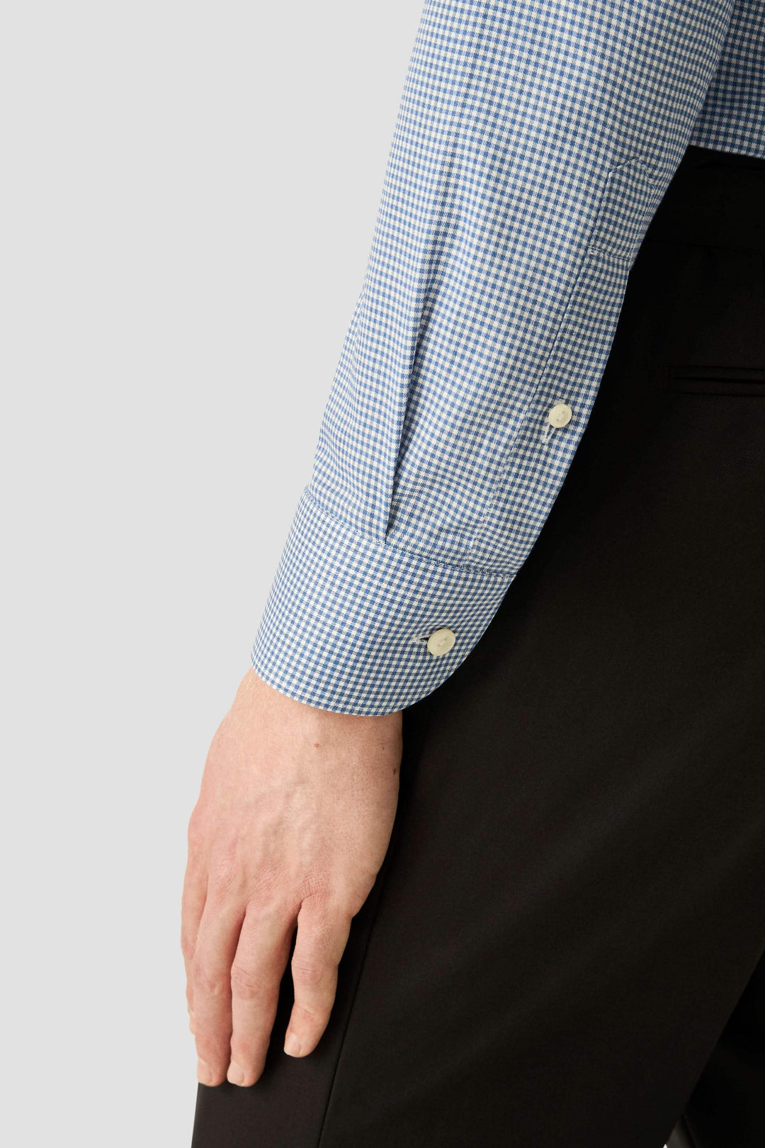 Manche de chemise motif carreaux avec boutons nacrés, coupe ajustée, idéale pour un style professionnel et élégant. Chemise motif carreaux.