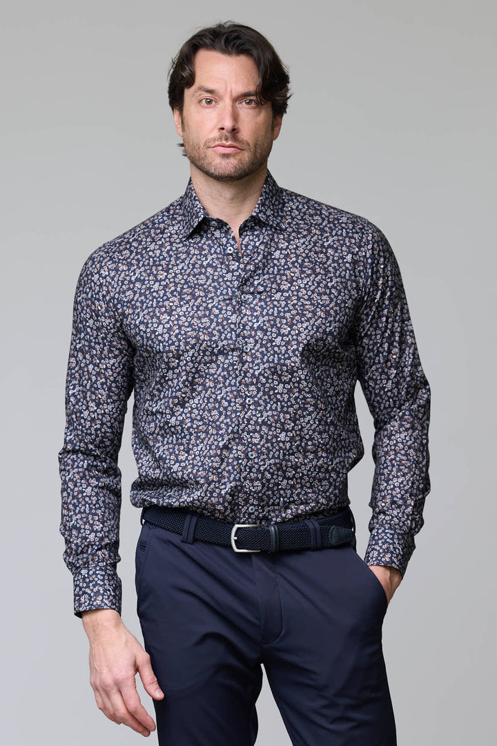 Homme portant chemise à motif floral abstrait avec fond foncé et coupe ajustée, élégante et moderne.