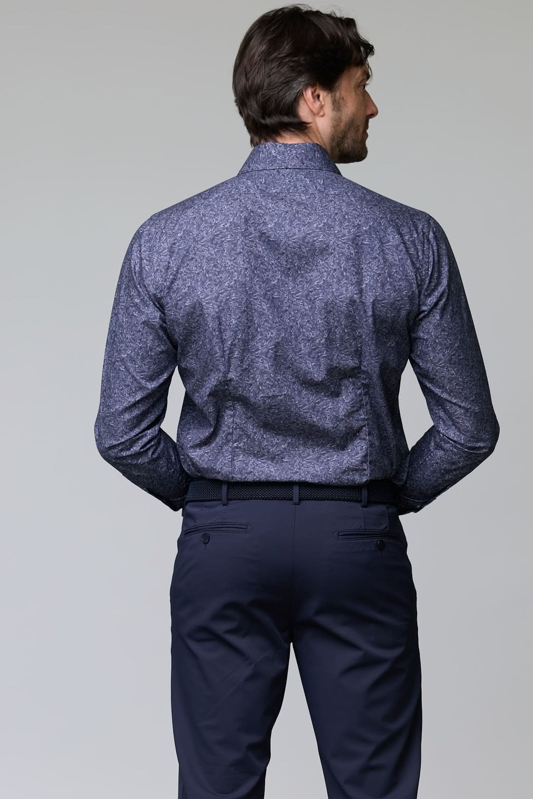 Homme portant une chemise à motif texturé bleu avec coupe ajustée et col classique, vue de dos.